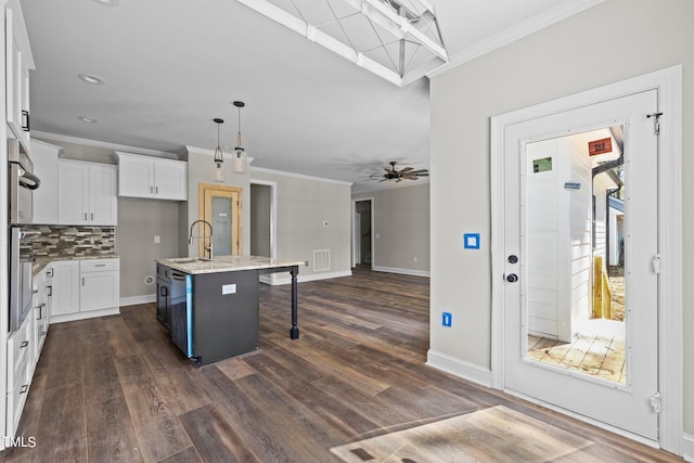 kitchen featuring decorative light fixtures, white cabinets, dark wood-type flooring, a center island with sink, and ceiling fan