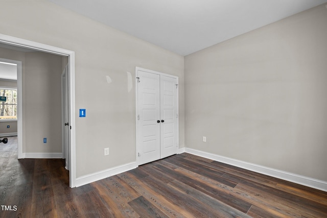 unfurnished bedroom with dark wood-type flooring and a closet