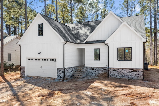 modern inspired farmhouse with a garage and central air condition unit