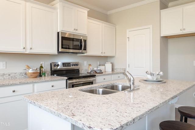 kitchen featuring white cabinets, ornamental molding, appliances with stainless steel finishes, and a kitchen breakfast bar