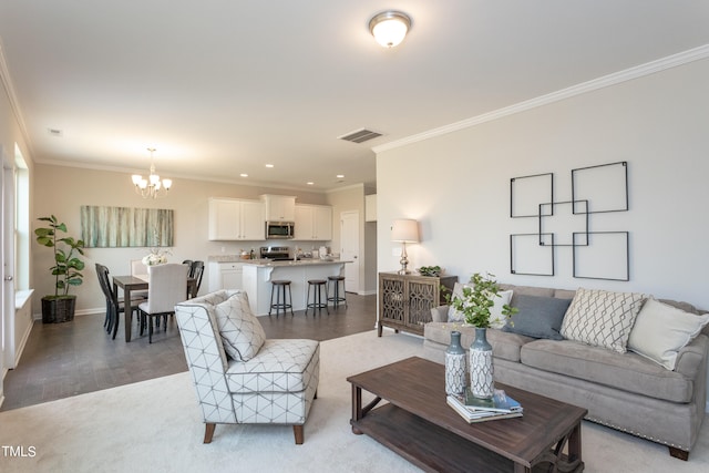 living room with crown molding, a notable chandelier, and light wood-type flooring