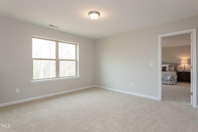 unfurnished room featuring light colored carpet