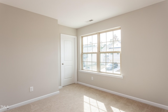 unfurnished room featuring light colored carpet