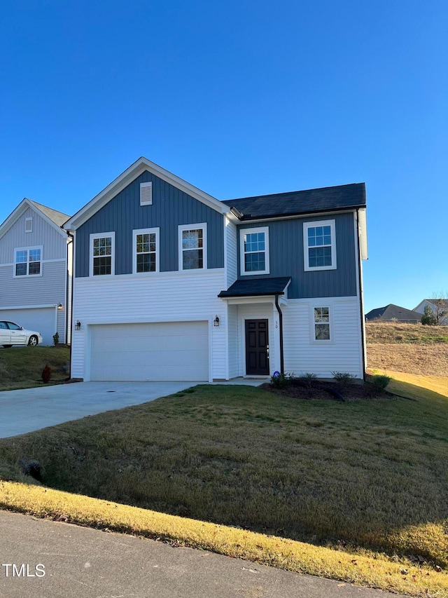 view of front of property featuring a front yard and a garage