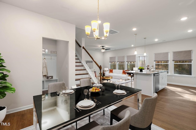 dining room featuring wood-type flooring and ceiling fan with notable chandelier