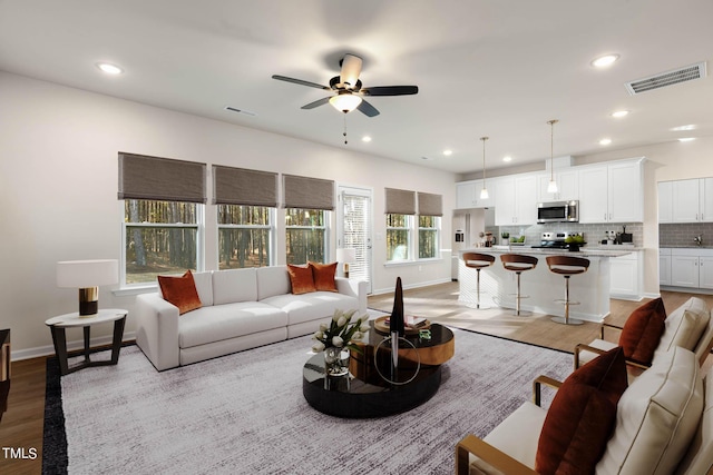 living room with ceiling fan and light hardwood / wood-style floors