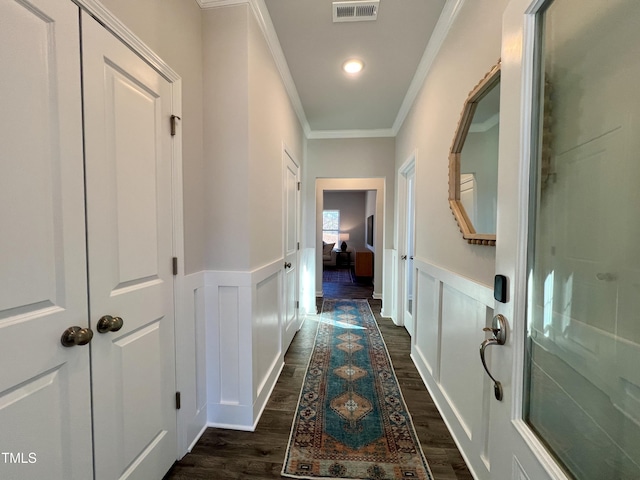 hall with dark wood-type flooring and ornamental molding