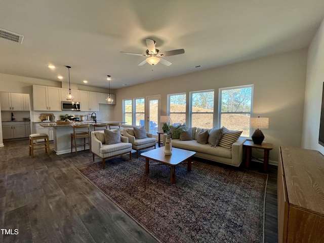 living room with ceiling fan and dark hardwood / wood-style flooring