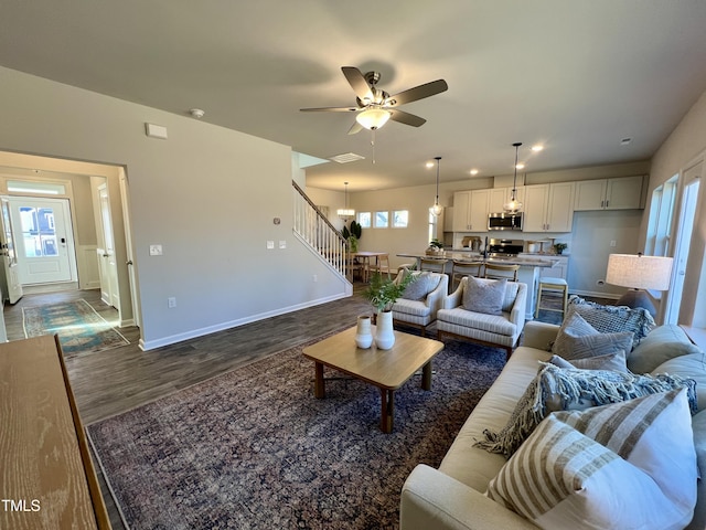 living room featuring ceiling fan and dark hardwood / wood-style floors