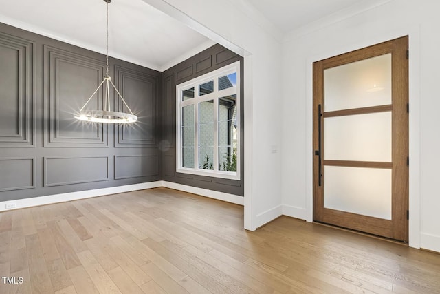 interior space featuring crown molding, a chandelier, and light hardwood / wood-style floors