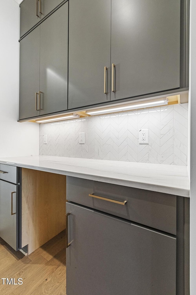 interior details with wood-type flooring and tasteful backsplash