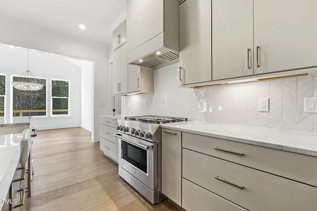 kitchen featuring an inviting chandelier, high end stainless steel range, light hardwood / wood-style flooring, decorative light fixtures, and light stone counters