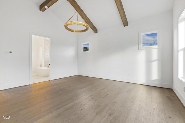 unfurnished living room featuring beamed ceiling, hardwood / wood-style floors, and high vaulted ceiling