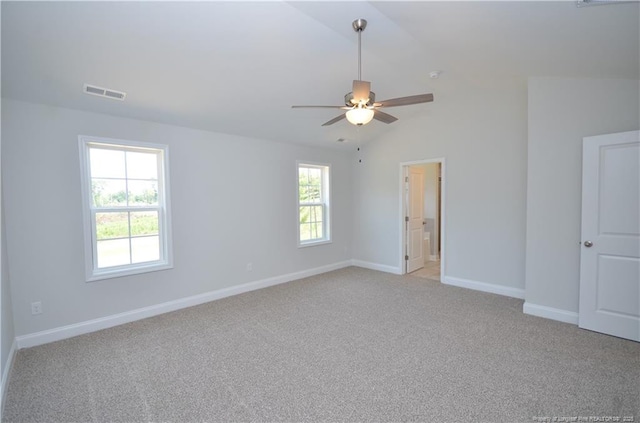 carpeted empty room featuring lofted ceiling, a wealth of natural light, and ceiling fan