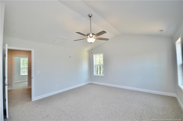 spare room with light carpet, plenty of natural light, and lofted ceiling