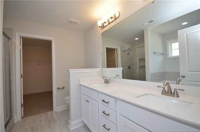 bathroom featuring vanity, toilet, and an enclosed shower