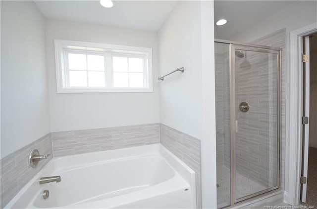 bathroom featuring separate shower and tub