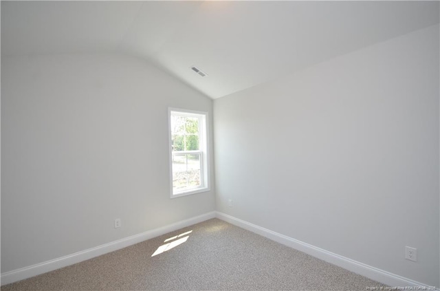 empty room featuring lofted ceiling and carpet floors