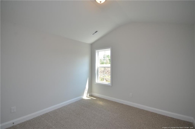 carpeted empty room with lofted ceiling