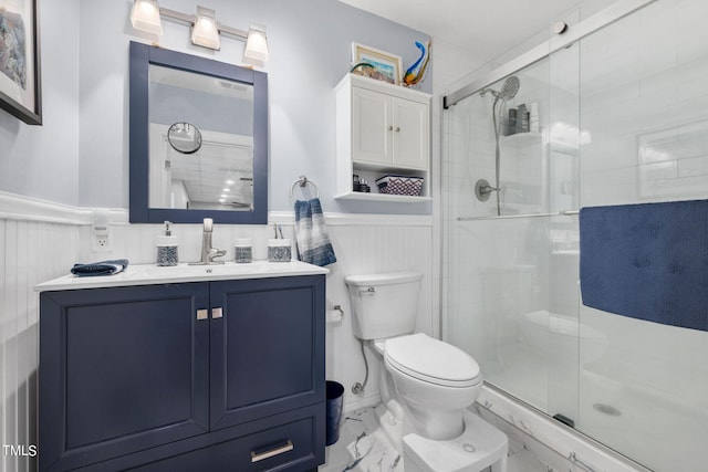 bathroom with tile walls, toilet, vanity, and an enclosed shower