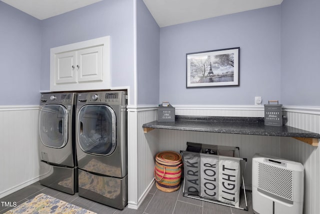 laundry room with dark tile flooring and independent washer and dryer