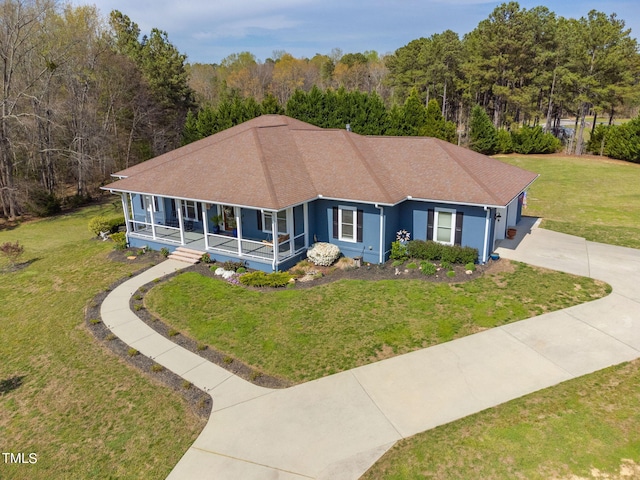 view of front of home with a front yard and a sunroom