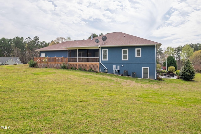 back of house featuring central air condition unit, a sunroom, and a yard