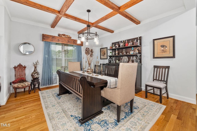 dining room with an inviting chandelier, beam ceiling, coffered ceiling, and light hardwood / wood-style floors