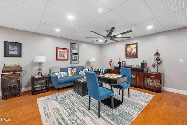 living room featuring light hardwood / wood-style floors, ceiling fan, and a paneled ceiling