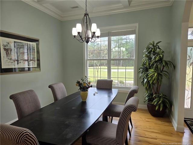 dining area featuring coffered ceiling, a chandelier, light hardwood / wood-style floors, and ornamental molding