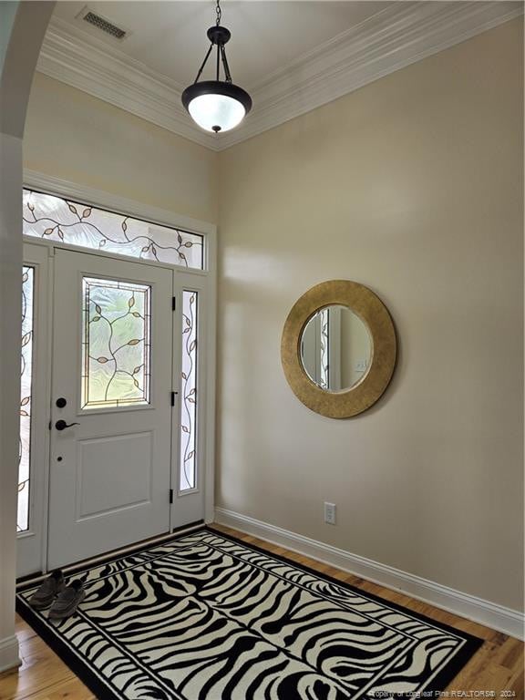 foyer entrance featuring crown molding and light hardwood / wood-style floors