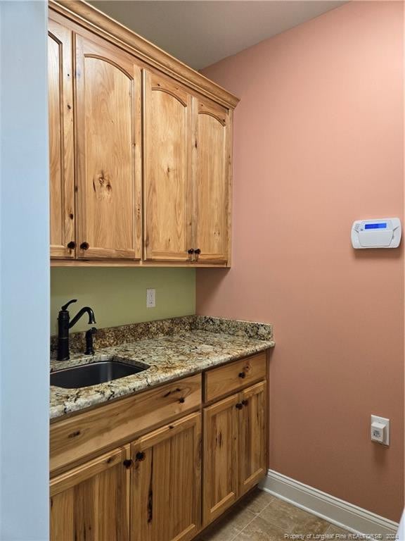 laundry room with light tile floors and sink