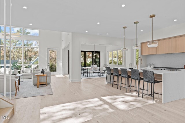 1435 Duplin Rd, Raleigh, NC 27607 - kitchen with modern cabinets, light brown cabinets, light wood-type flooring, recessed lighting, and a kitchen breakfast bar