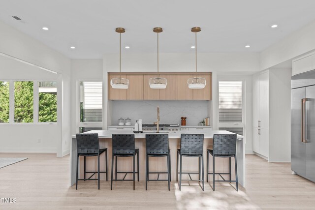 1435 Duplin Rd, Raleigh, NC 27607 - kitchen featuring built in refrigerator, modern cabinets, light countertops, light wood-type flooring, and backsplash