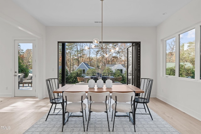 1435 Duplin Rd, Raleigh, NC 27607 - dining area featuring light wood finished floors, healthy amount of natural light, a chandelier, and baseboards