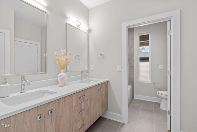 1435 Duplin Rd, Raleigh, NC 27607 - bathroom featuring double vanity, tile patterned floors, toilet, baseboards, and a tub