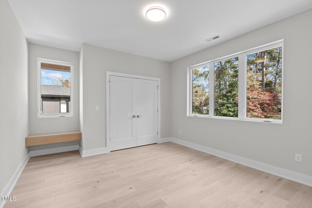 1435 Duplin Rd, Raleigh, NC 27607 - unfurnished bedroom featuring light wood-style floors, multiple windows, and baseboards