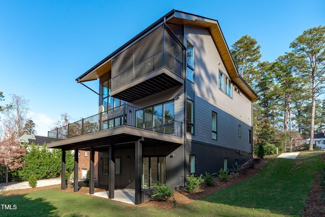 back of property with a lawn and a patio