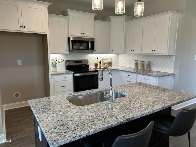 kitchen featuring a center island with sink, stainless steel appliances, white cabinets, and sink