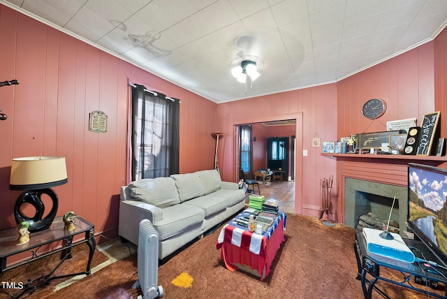 carpeted living room with ceiling fan and crown molding