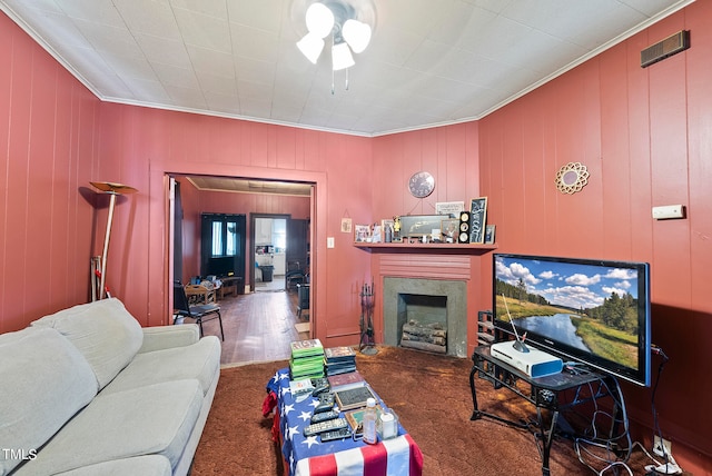 living room featuring a high end fireplace, ornamental molding, and dark carpet