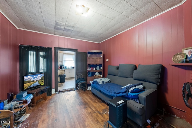 interior space with dark hardwood / wood-style flooring, wooden walls, and ornamental molding