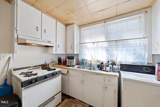 kitchen with sink, washer / dryer, white cabinets, and white gas stove