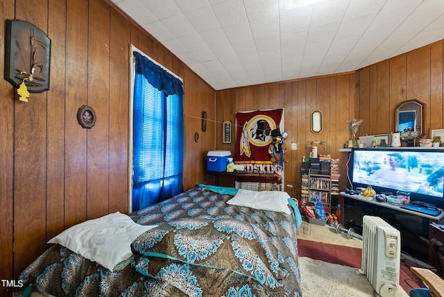 bedroom featuring wooden walls and carpet floors