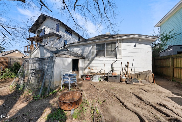 rear view of property featuring an outdoor fire pit