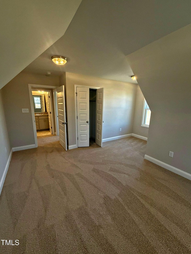 bonus room with light carpet and lofted ceiling