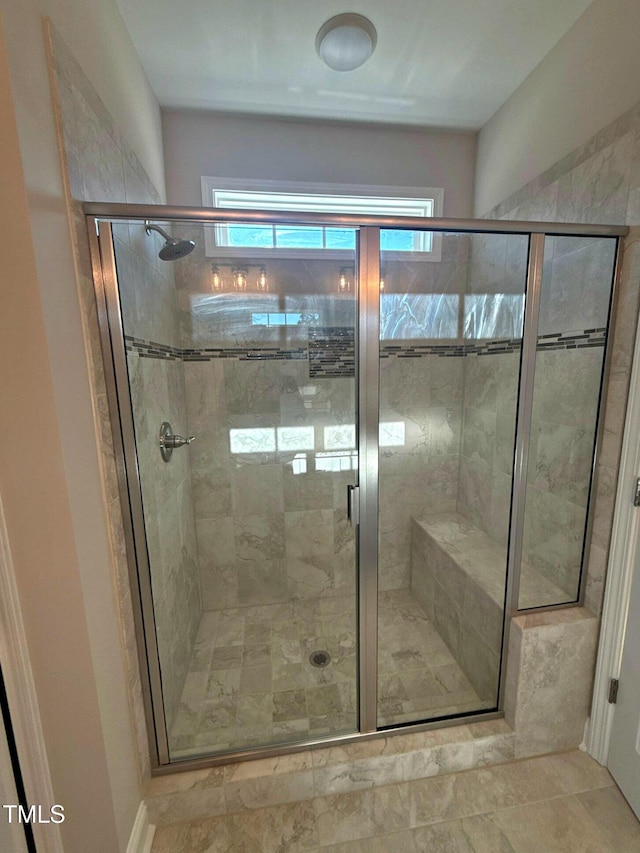 bathroom featuring a shower with shower door