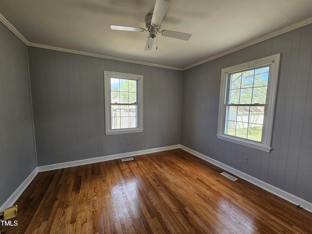 spare room with crown molding, dark hardwood / wood-style floors, and ceiling fan