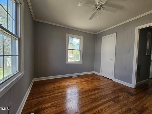 unfurnished room with ceiling fan, crown molding, and dark wood-type flooring