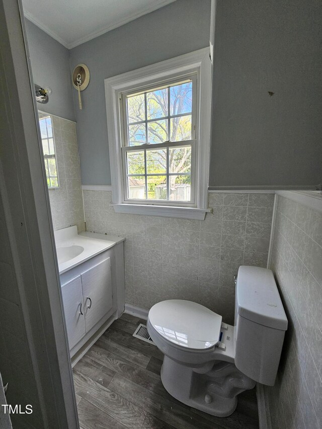 910 Marshall St, Roanoke Rapids, NC 27870 - bathroom with wood-type flooring, toilet, tile walls, ornamental molding, and vanity